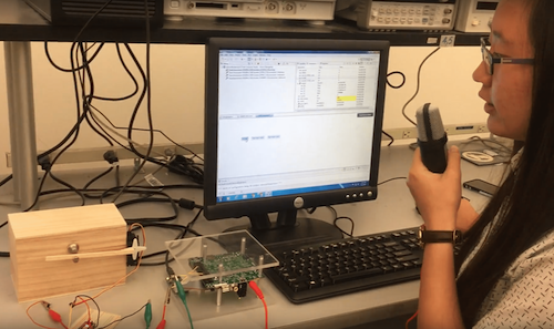 photo of me speaking into a microphone with a wooden locked box linked to the computer